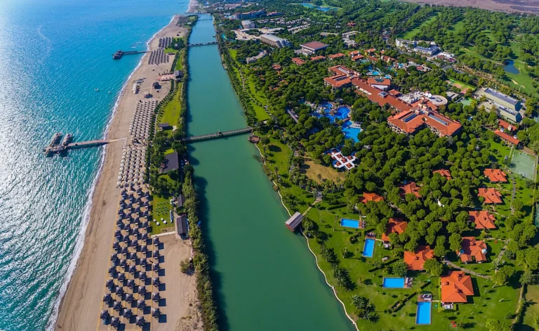 Gloria Golf Resort Aerial View | Golf Course and the Hotel on the left and River and Beach On the mediterranean trough the right side.